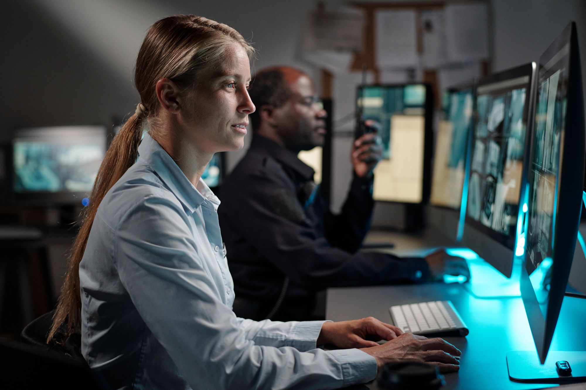 Two operators monitoring systems on screen overnight