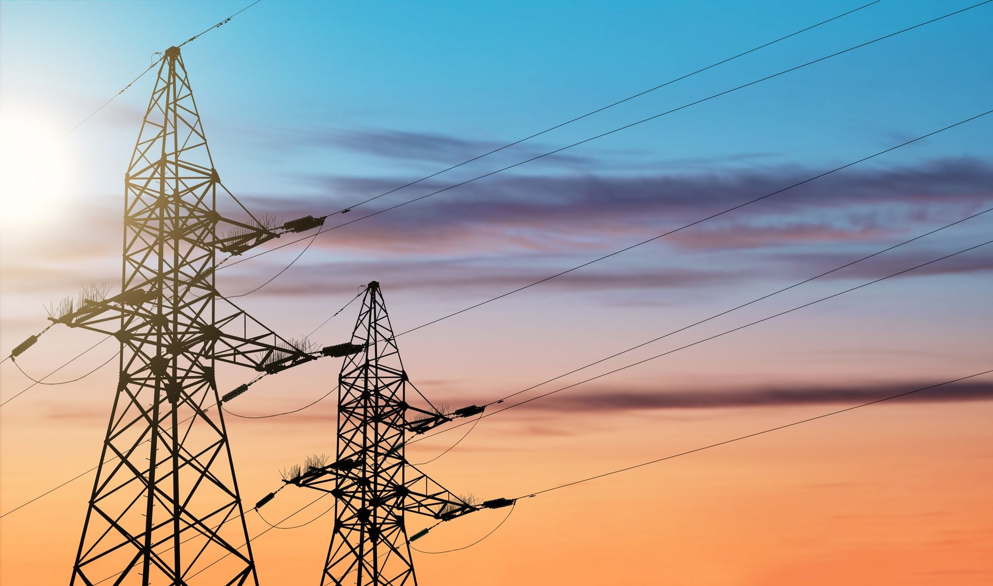 Transmission towers silhouetted at dusk