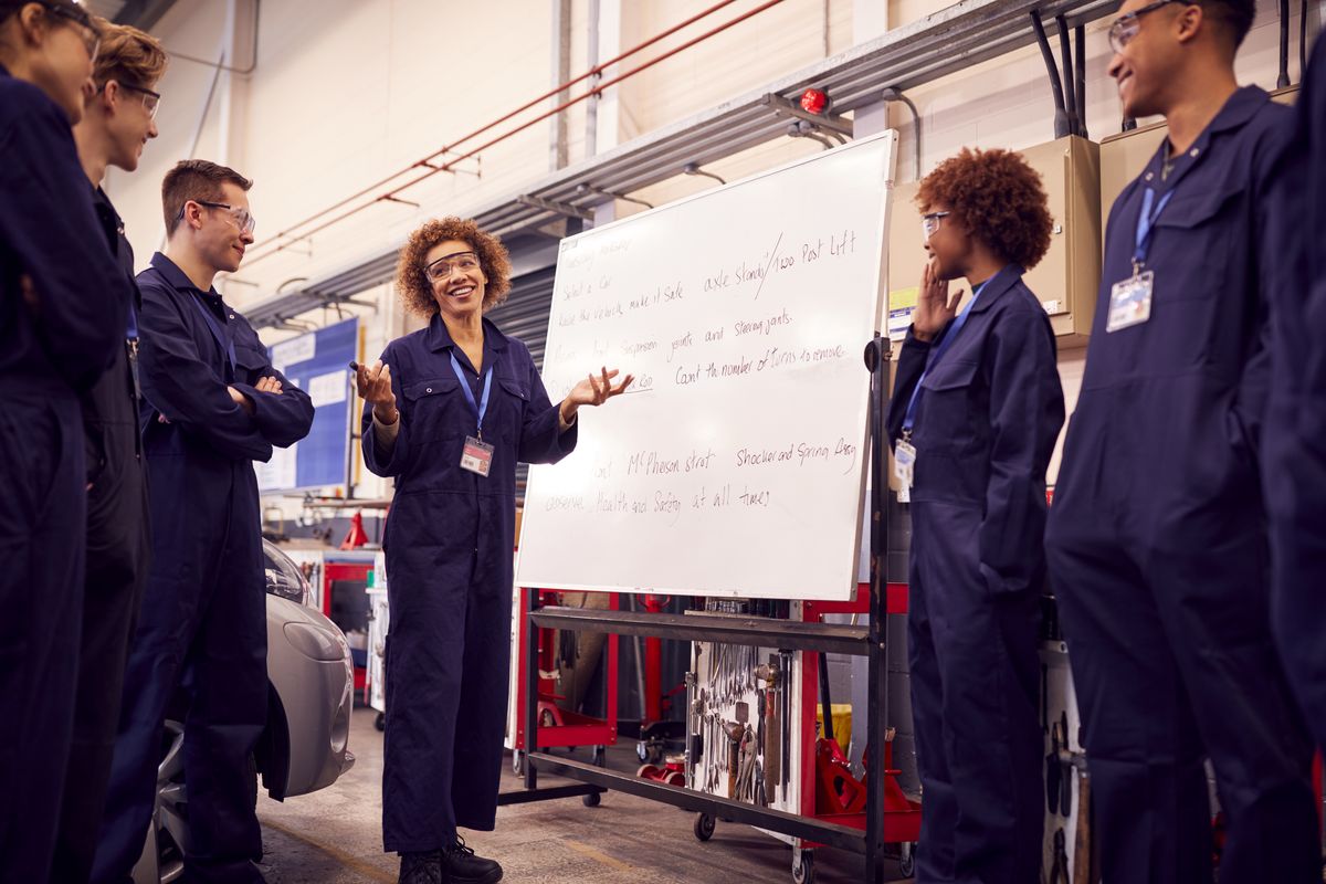 Instructor walking a crew through a task sequence at a whiteboard